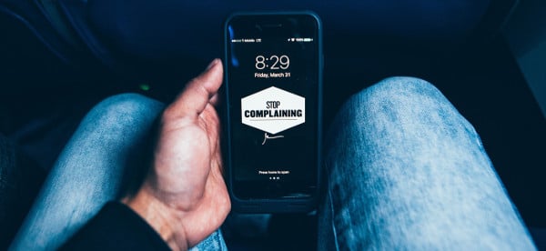 take personal responsibility - man holding phone that says stop complaining