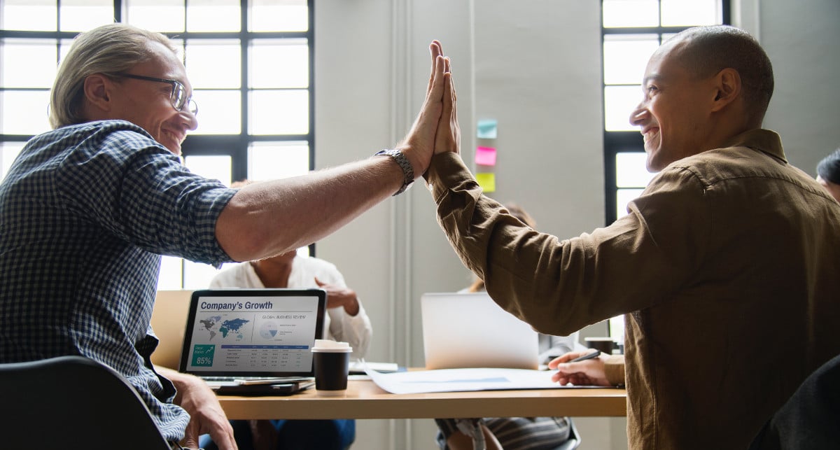 importance of time management - two men giving high five in office