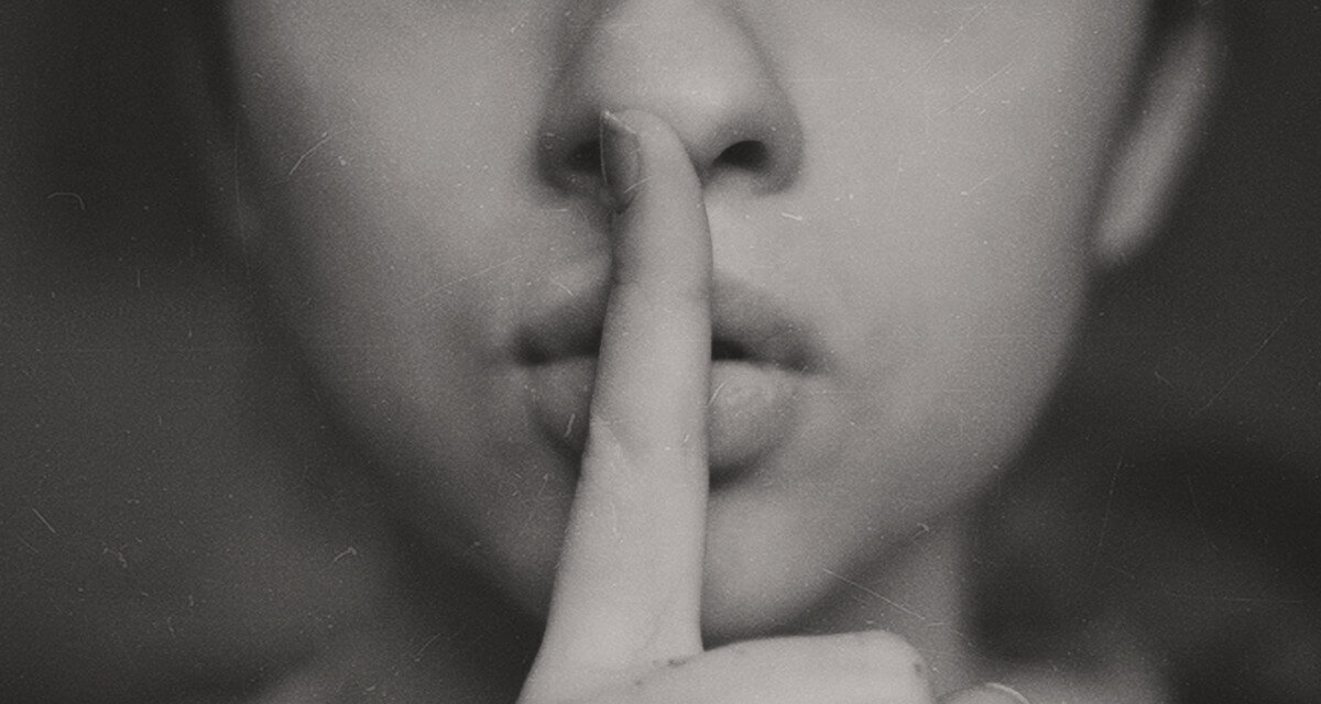 secrets to accomplishing goals - woman with finger over mouth